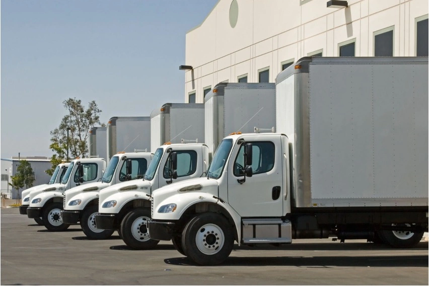Commercial truck rental fleet parked at logistics facility